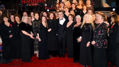 Getty Images Kristin Scott Thomas, Gareth Malone and Sharon Horgan with the Combined Military Wives Choir at their London UK film premiere in February