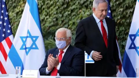 Reuters US ambassador to Israel David Friedman claps as Israeli Prime Minister Benjamin Netanyahu walks behind him at a ceremony in the settlement of Ariel in the occupied West Bank (28 October 2020)