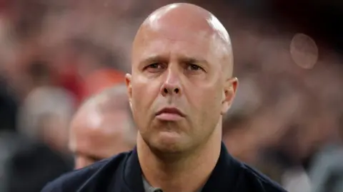 A close up head shot of Arne Slot at Anfield stadium