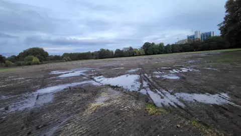 Save Gunnersbury Park A muddy field with puddles and tyre tracks