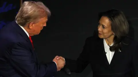 Donald Trump and Kamala Harris shaking hands 