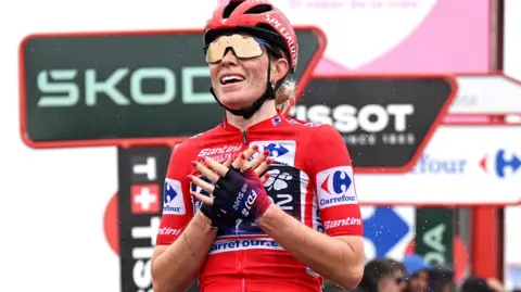 Demi Vollering crosses her hands in celebration after winning the 2025 Vuelta Femenina title