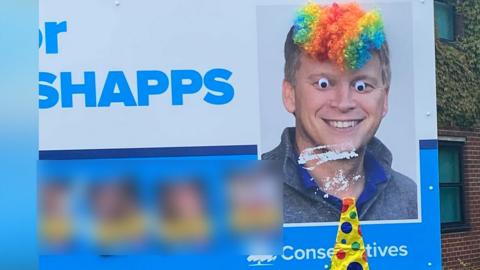 defaced poster of Grant Shapps