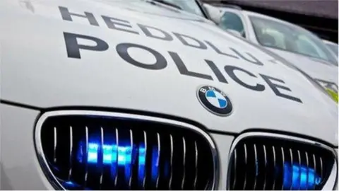 A police car with police written on the bonnet in Welsh and English