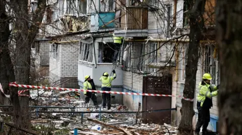Reuters Emergency responders work at the site of a Russian drone strike on an apartment building