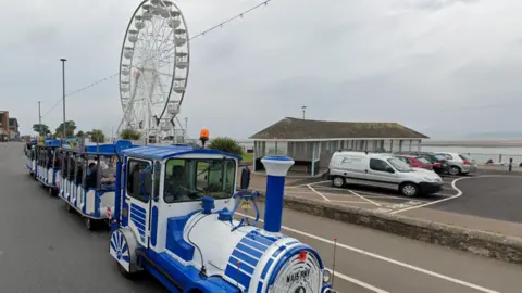Google Exmouth's seafront, with a road train and ferris wheel