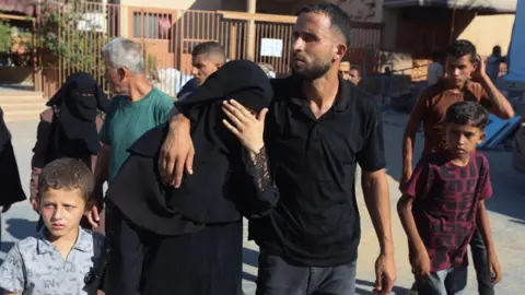 The mother of Amal Abu Khater, 10, is comforted outside Nasser hospital, in Khan Younis, southern Gaza (24 August 2026)