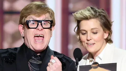 Getty Images Elton John and Brandi Carlile presenting an award