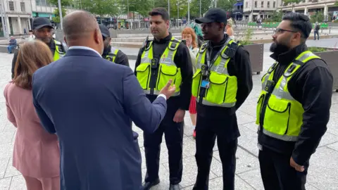 Five officers are wearing reflective jackets and facing the mayor and PCC