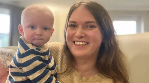 Lucy, holding Alfie, both looking at the camera