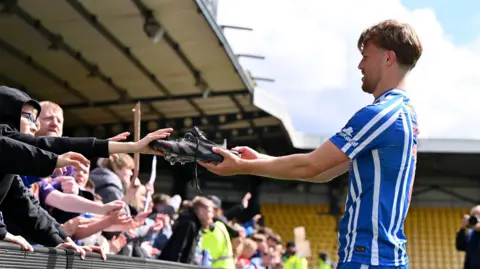 David Watson hands his boots to a Killie fan after a 4-1 win at Livingston on the final day of the SPL season last month.