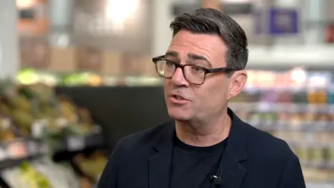 Andy Burnham in a black jacket and t shirt.