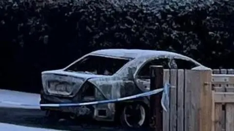 The skeleton of a car that has been put out following a fire