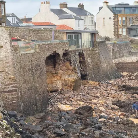 Scott Orr Brickwork on the sand and a broken wall underneath a house in Fife.
