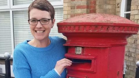 Ms Johnson with a postbox