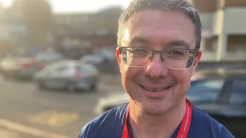 Prof Damian Roland standing outside a hospital building