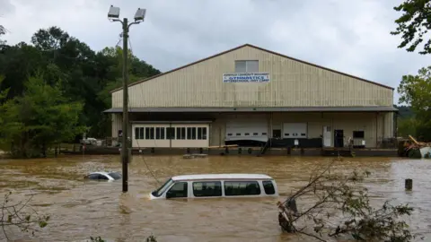 Getty Images A car is submerged in water as Storm Helene hits Asheville, North Carolina.