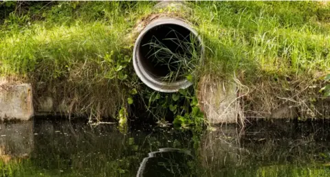 Getty Images Sewage pipe at river