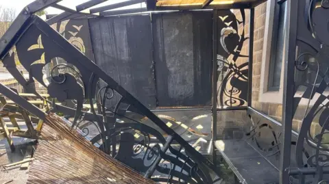 Danny Black Damaged smoking shelter outside a pub