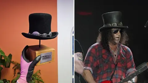 Hojo Hattery/Holly Johnson/PA Media Two images, side by side. On the left, a gloved hand holds the wooden base of a trophy with a metal plaque on the side of the wood that says "Music Awards". On the top of the wooden base, a metal spike goes up to hold the bottom of a small black top hat, with silver badges around the base. On the right image, a man with long black hair past his shoulders and wearing a red and black lumberjack-style checked shirt, plays guitar. On his head is a black top hat with similar silver badges around its rim.