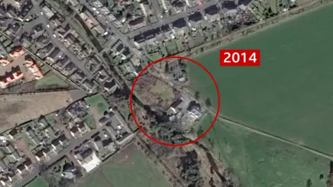 Google Earth A satellite image of the site located in Innerleith near the Scottish Borders. The site is marked with a red circle in the centre and the year '2014' is also marked to the right, in red and white. It looks like a domestic area around the site and the changes are minimal to the previous image. 