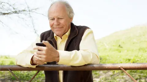 Getty Images A man holding a mobile phone