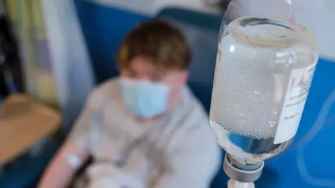 A patient receiving immunoglobulin infusion. The patient's face is out of focus.