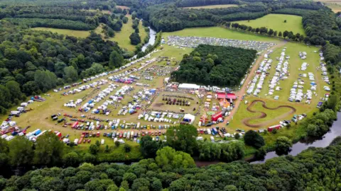 Aerial view of a large park with caravans and steam vehicles visible