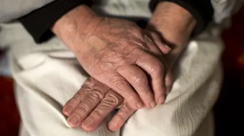 PA Media Elderly person's hands
