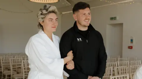 4c585720-536b-11f1-b319-63ed6ac90e5f.png Bride weds in dressing gown, slippers and rollers as 'it's what married life is like'