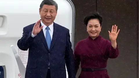 China's President Xi Jinping (L) and his wife Peng Liyuan wave upon their arrival for an official two-day state visit at Orly airport, south of Paris on May 5, 2024.