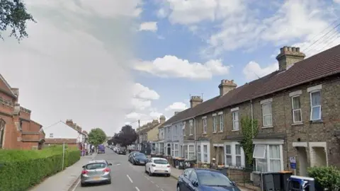 Iddesleigh Road in Bedford is a mix of residential terraced houses and small businesses. There is a large redbrick church on the left of the street and cars are parked opposite on the road