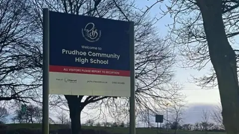 BBC Entrance sign at Prudhoe Community High School. The background of the photo shows a number of trees.