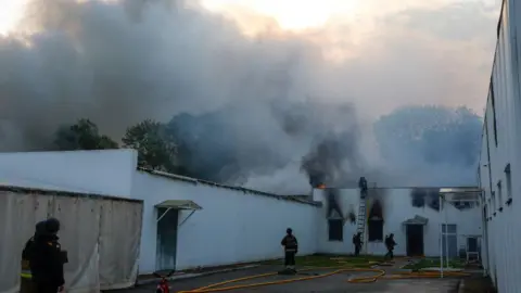 Reuters Firefighters work at the site of a private enterprise hit by a Russian drone strike, amid Russia's attack on Ukraine, outside of Kyiv, Ukraine May 18, 2025.