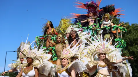 Reuters female groups in colored costumes and fur in floating fell for a parade.
