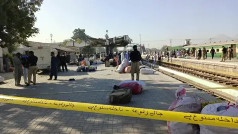 AFP Police and debris behind a cordon at the railway station