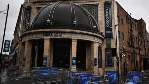 Getty Images O2 Academy’s domed entrance with “Asake – sold out” signage, with stacked barriers in front of the doors.