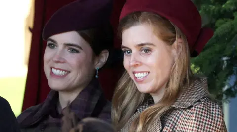 Close crop of Beatrice and Eugenie both smiling, wearing hats and coats pictured outdoors at the Sandringham Christmas Day service in December 2025.