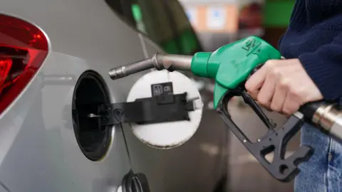 PA Media A person filling a car with fuel