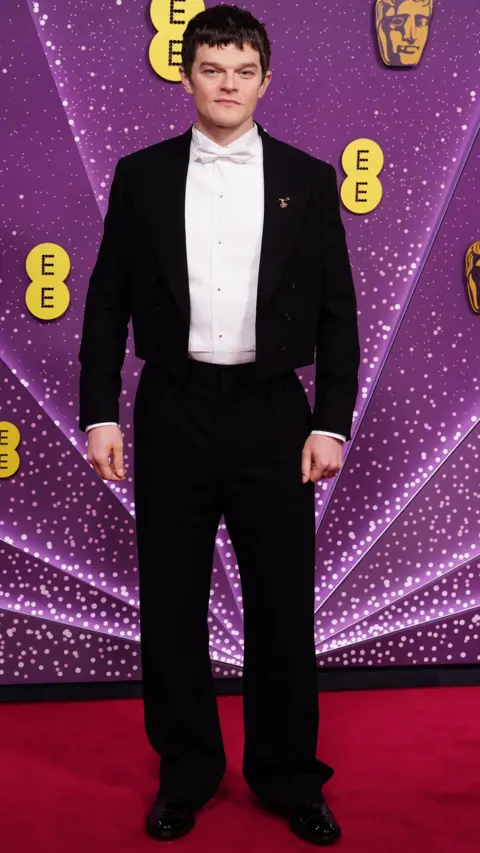 Getty Images Robert Aramayo in a black suit and white shirt