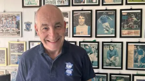 BBC Supporter Rob Shannon stands in front of memorabilia