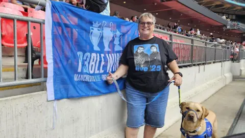 Lynn Ratcliffe Lynn Ratcliffe wearing long denim shorts and an Oasis T-Shirt, with Barnby, her support Labrador, wearing a blue harness