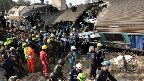 Reuters Rescue workers crowd around a damaged carriage