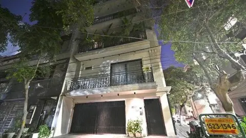 AFP via Getty Images A view outside the white-grey four-storey residence of Saurabh Luthra, one of the owners of the 'Birch by Romeo Lane' nightclub where the fire tragedy occurred resulting in the death of 25 people. 