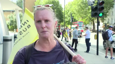 Woman with sunglasses on headholding a yellow flag