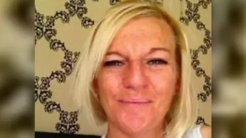 Pamela Wilson, a woman with blonde hair, smiles for the camera