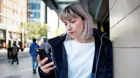 Getty Images A woman looking at a phone