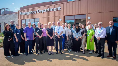Colleagues from Wirral University Teaching Hospital, NHS England North West and NHS Cheshire and Merseyside pictured outside the new urgent and emergency care facility. 