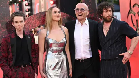 Getty Images Alfie Williams, Jodie Comer, Danny Boyle and Aaron Taylor Johnson standing together on the red carpet at the 28 Years Later premiere