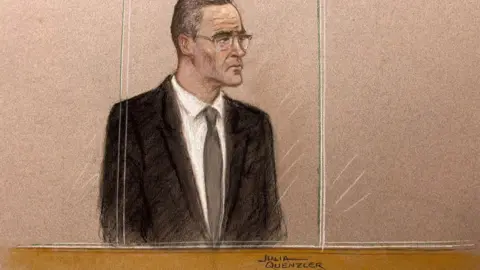 Julia Quenzler/BBC A sketch of Paul Doyle, 54, standing in a dock behind a plastic screen wearing a black suit over a white shirt and tie